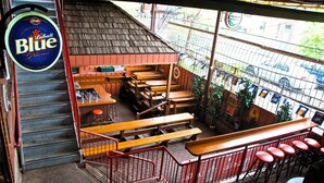 A restaurant with outdoor seating, a beer sign, and a view of the street. - Madison Manor Boutique Hotel (Toronto)