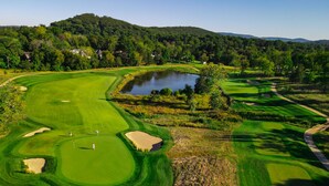 A golf course with bunkers, a pond, and a hilly backdrop. - Boar's Head Resort (Charlottesville)