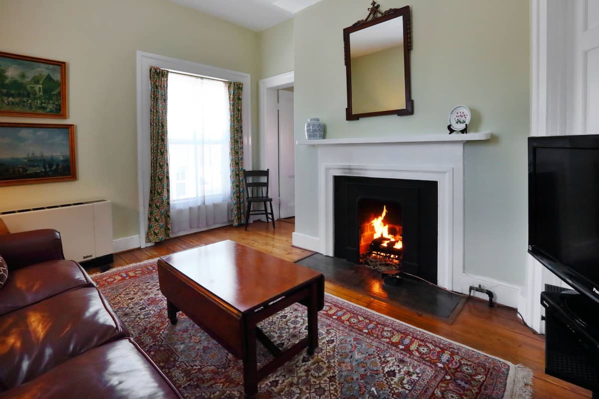 A living room with a fireplace, a sofa, a coffee table, and a television.