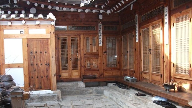 A traditional wooden building with a stone courtyard, wooden doors, and a tiled roof. - Hyosunjae Hanok Guesthouse (Seoul)