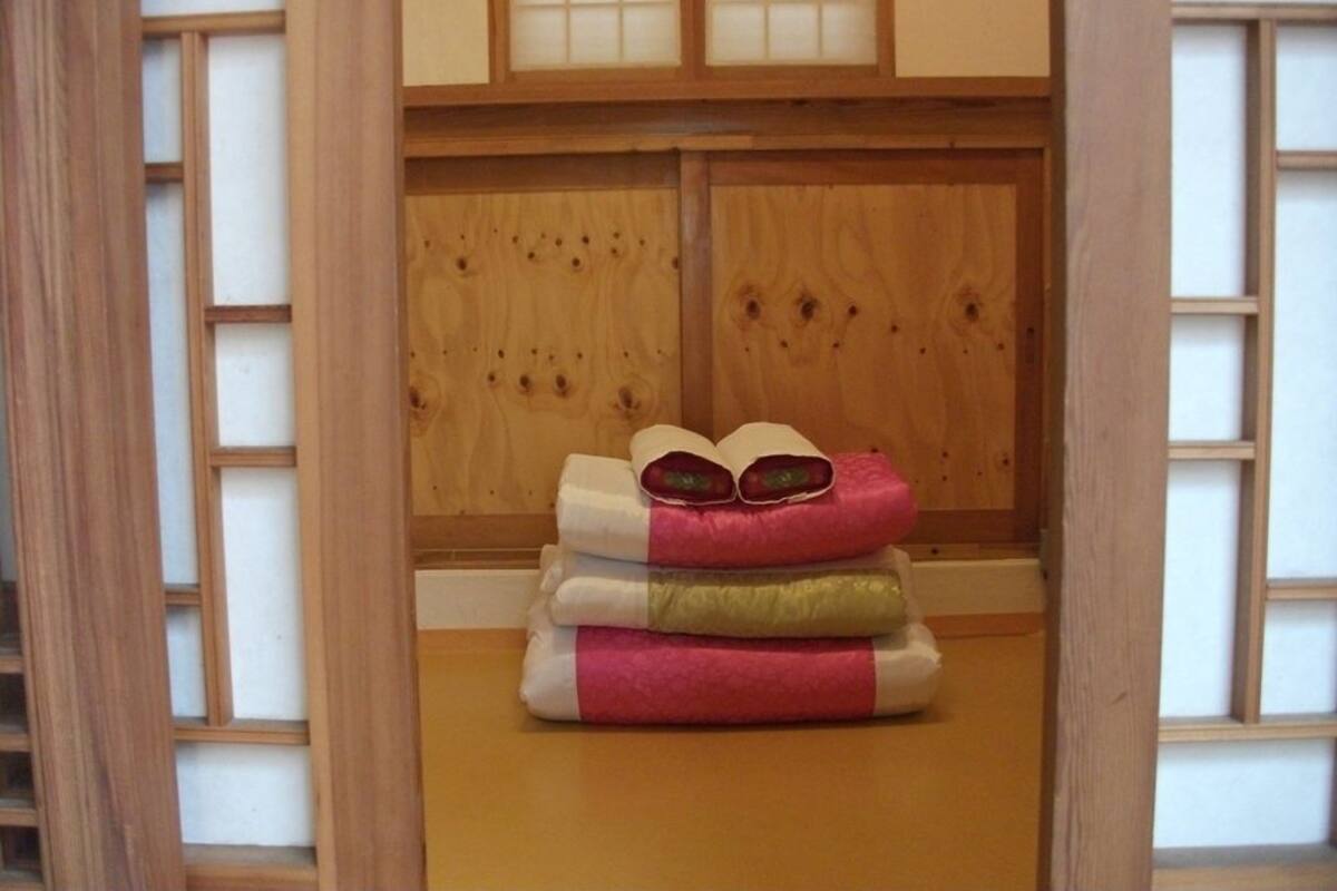 Une pile de serviettes pliées dans une pièce dotée de portes coulissantes traditionnelles de style japonais.