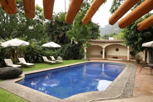 Una piscina al aire libre, camas de piscina gratis, sombrillas