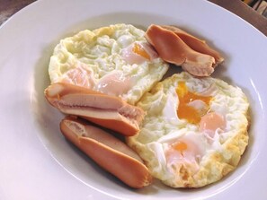 A plate with scrambled eggs, ham, and a fried egg. - NY TH Hotel (Si Racha)