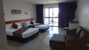 Habitación de hotel con dos camas, un sofá, televisión y balcón con cortinas.