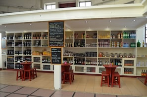 Loja de bebidas com prateleiras cheias de garrafas e um quadro negro com o cardápio.