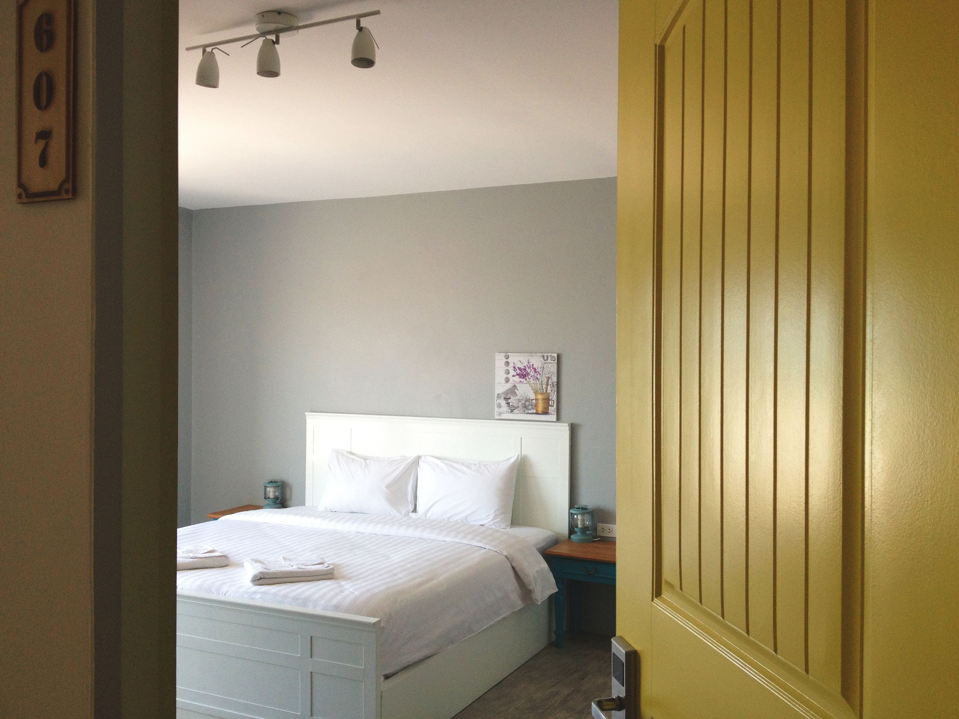 A bedroom with a bed, bedside table, and a nightstand.