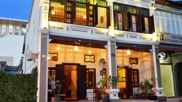 A two-story colonial-style building with a balcony, large windows, and a sign for 'Kedai Aluminium Enterprise SD'. - Noordin Street House (George Town)