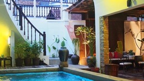 A pool area with a staircase, potted plants, and outdoor seating. - Noordin Street House (George Town)
