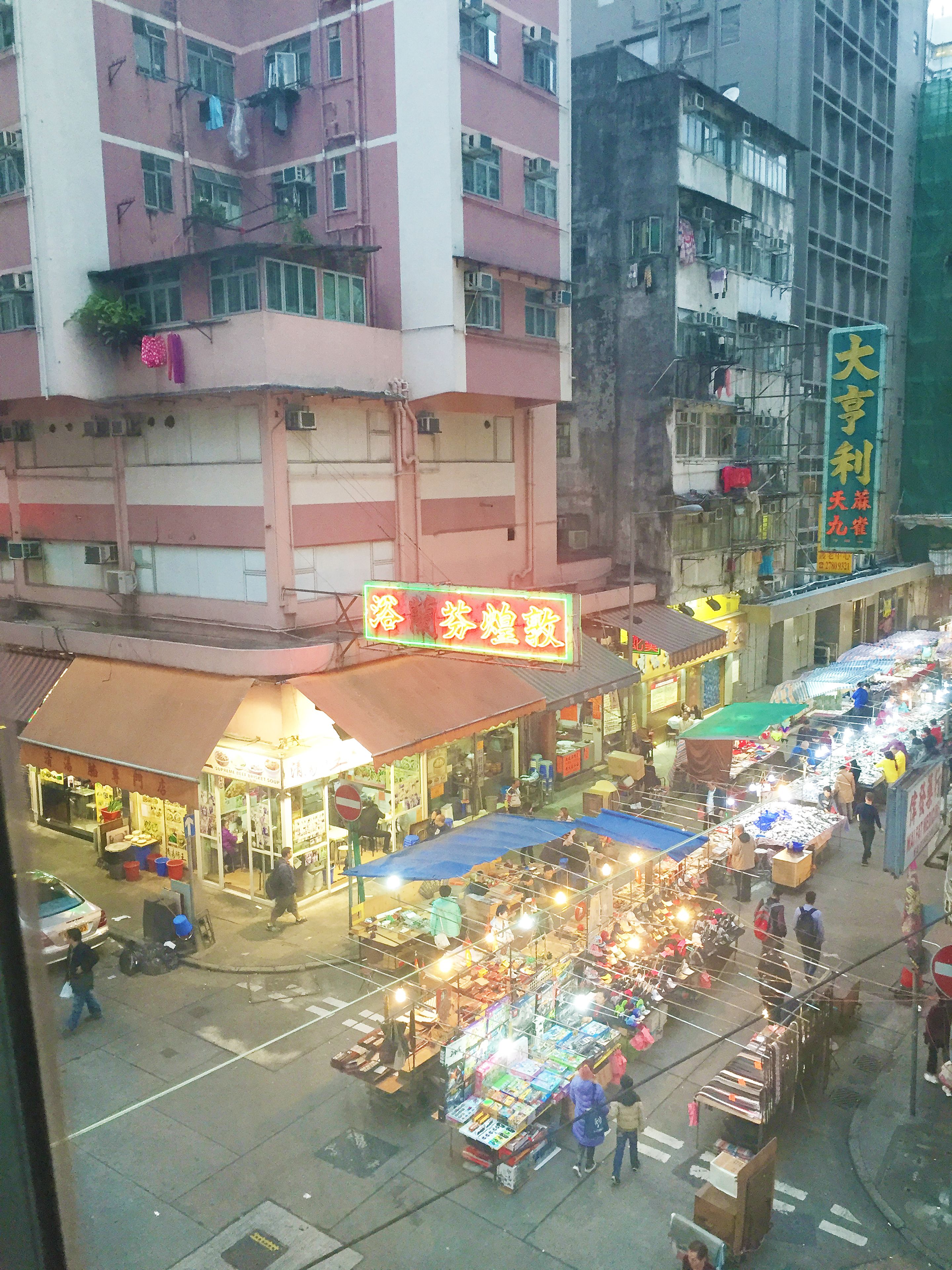 A bustling street market with various stalls and shops.