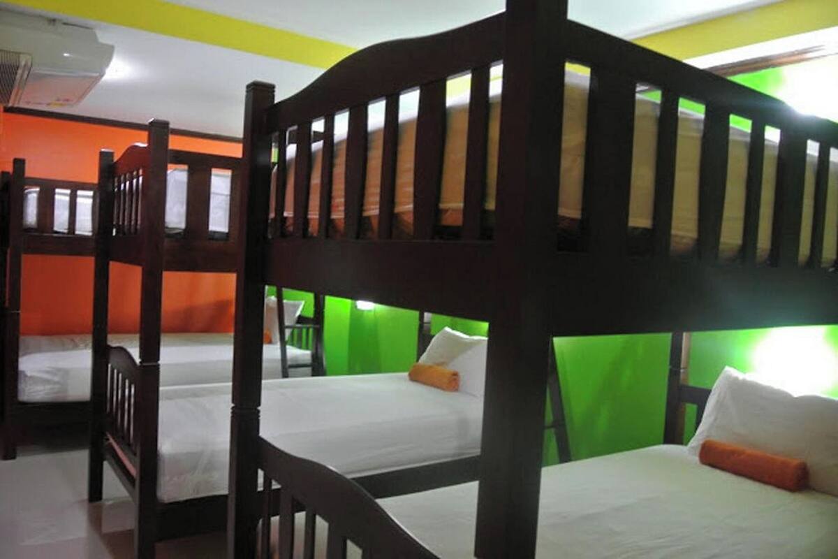 A room with bunk beds, green walls, and a white ceiling.
