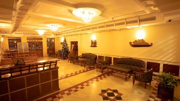 A lobby with a reception desk, seating area, and a Christmas tree.