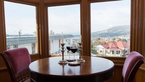 A round wooden table with two chairs, three candles, and two wine glasses. - Motel Mayfair on Cavell (West Hobart)