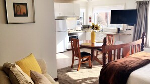 A compact, modern living space with a kitchenette, a dining area, and a bedroom. - Motel Mayfair on Cavell (West Hobart)