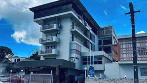 A multi-story building with balconies, a gated entrance, and a clear sky. - Southern Cross Hotel Fiji (Suva)