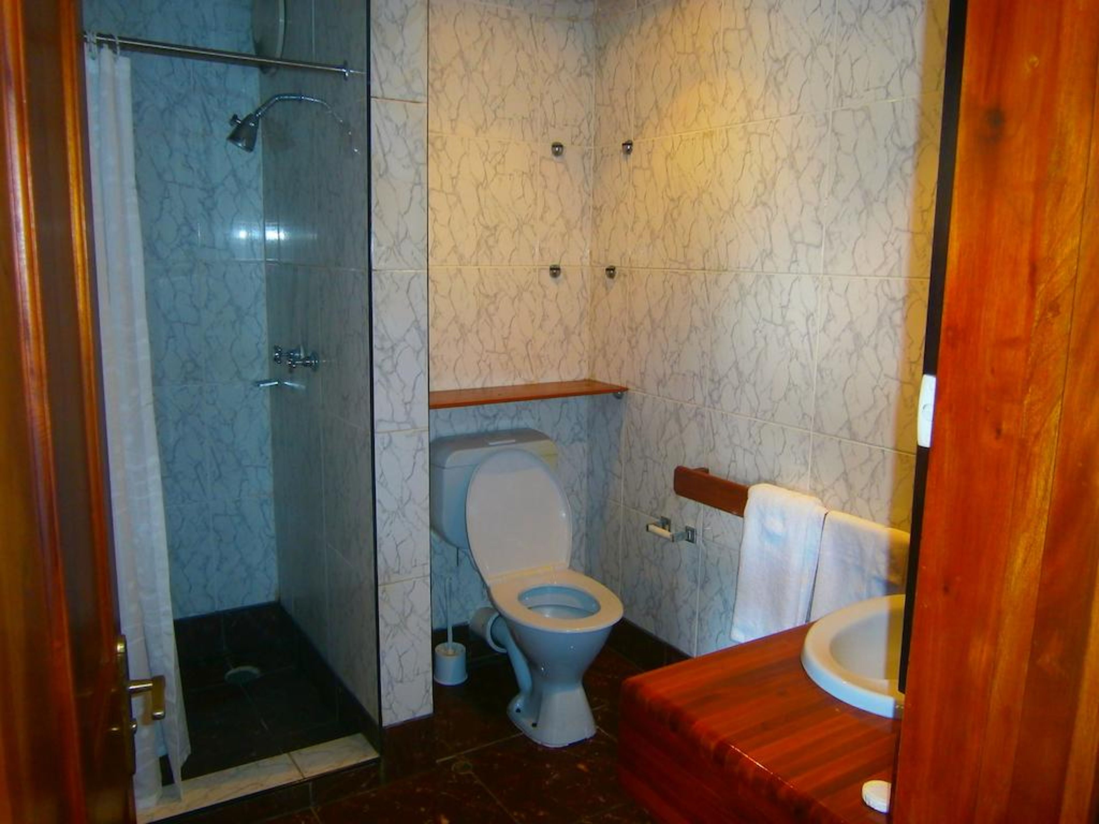 Une salle de bain avec une douche à parois de verre, des toilettes et un lavabo.