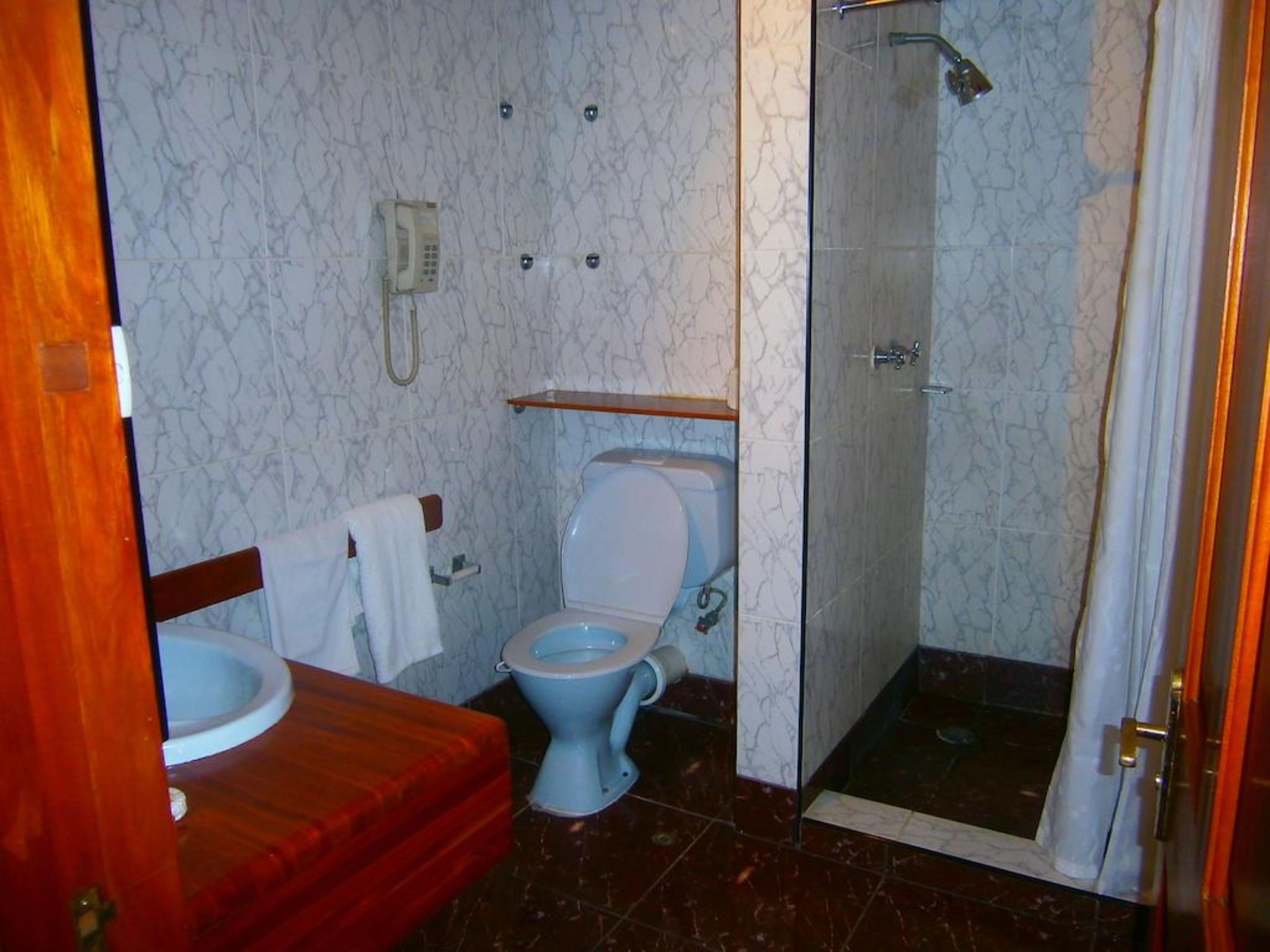 A bathroom with a toilet, sink, and shower.