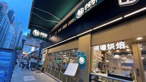 A street view with a bakery displaying its menu and pastries. - Move Inn (Hong Kong)