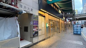 A hotel with a sign reading "Moyne Inn Hostel" and a neon sign above the entrance. - Move Inn (Hong Kong)