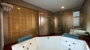 A modern bathroom with a large bathtub, a glass shower enclosure, and a wooden vanity with a sink. - Izumi Hotel Bukit Bintang (Kuala Lumpur)