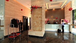 A hotel reception area with a modern design, a reception desk, and a wall-mounted flower arrangement. - Izumi Hotel Bukit Bintang (Kuala Lumpur)