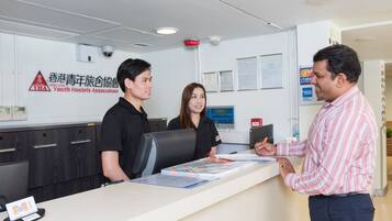 A reception desk with a sign for the Youth Hostels Association, a computer, and a counter with brochures.