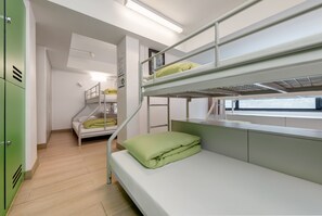 A bunk bed room with a green mattress and a window with a view. - YHA Mei Ho House Youth Hostel (Kowloon)