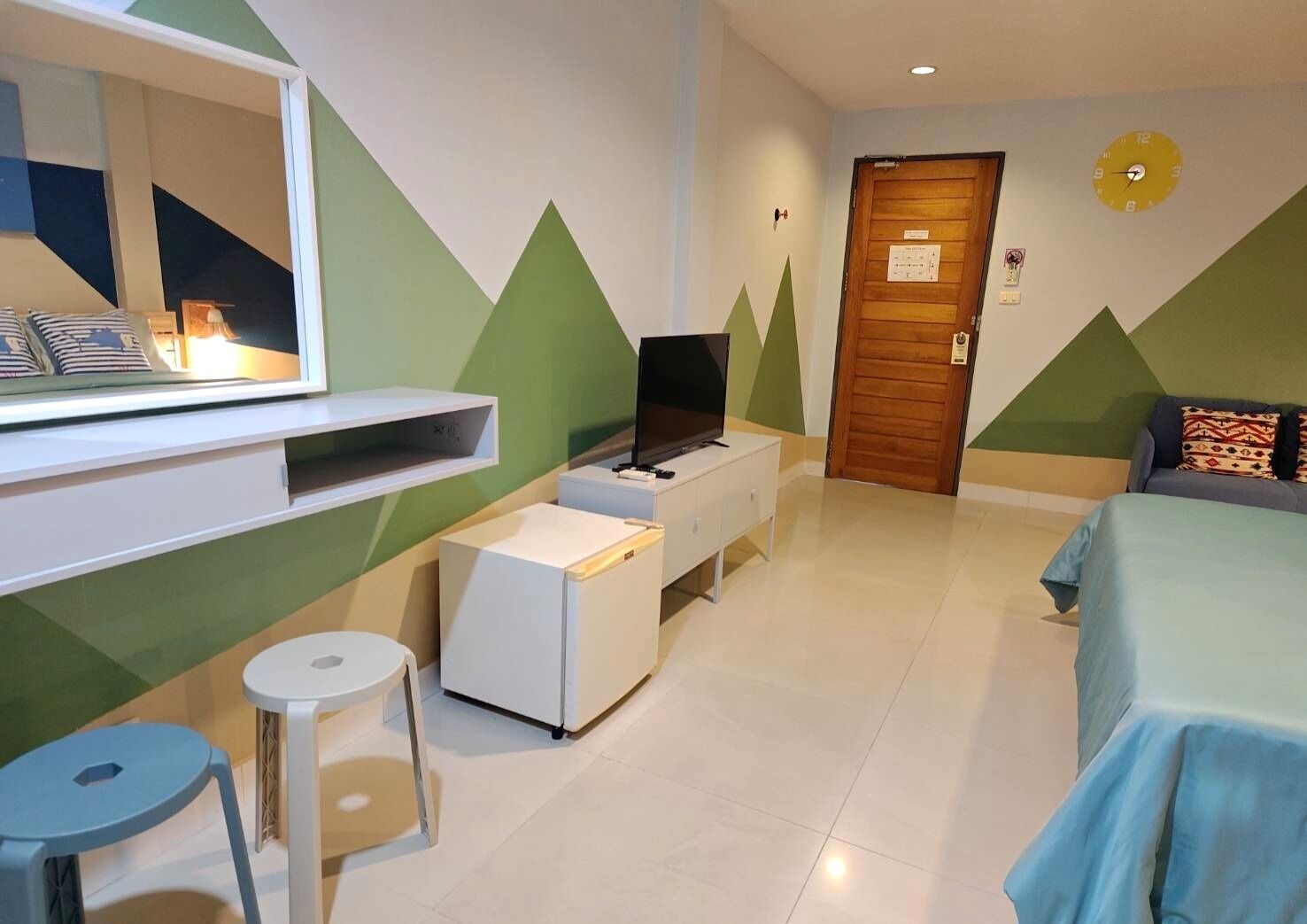 A hotel room with a bed, a TV, a small table, and a chair.