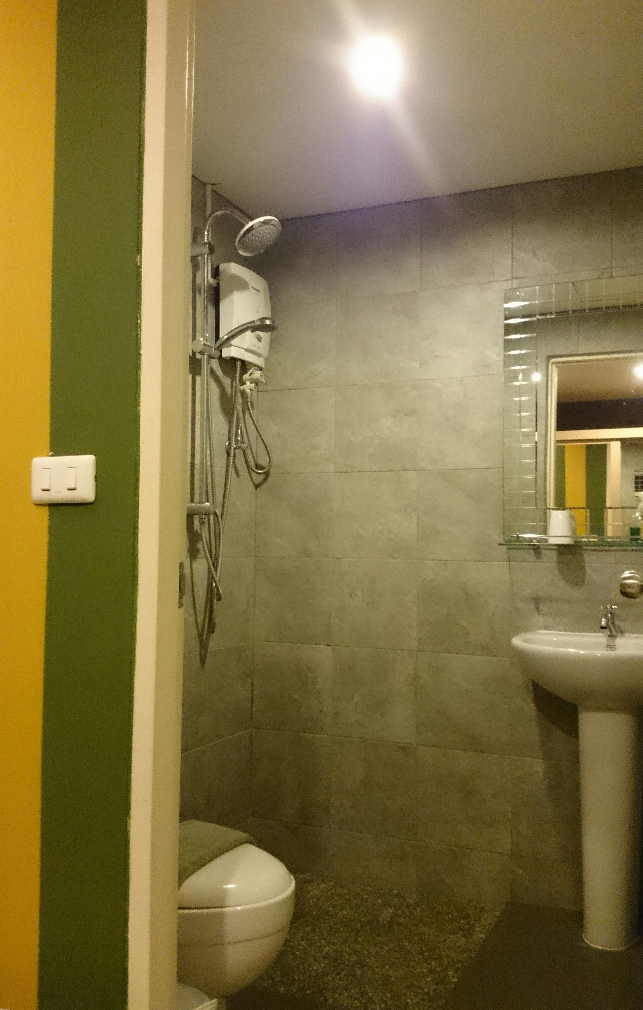 A bathroom with a shower, toilet, and sink.