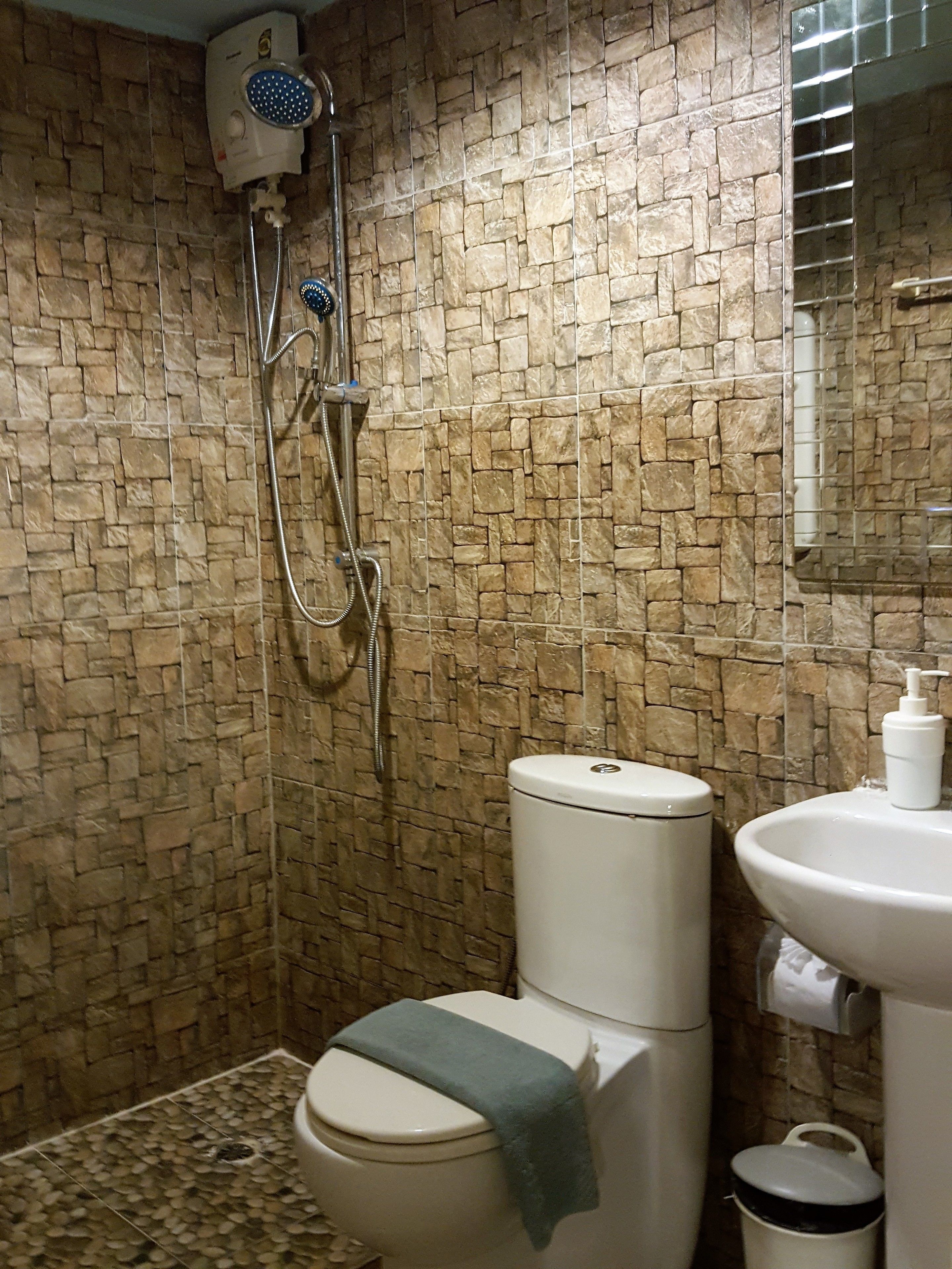 A bathroom with a shower, toilet, and sink.