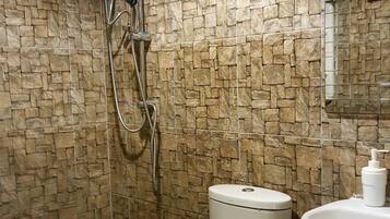 Un baño con ducha, inodoro y lavamanos.