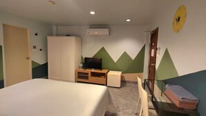 A hotel room with a bed, a TV, a wardrobe, a desk, and a chair. - Limburi Hometel (Patong)