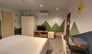 A hotel room with a bed, a TV, a wardrobe, a desk, and a chair. - Limburi Hometel (Patong)