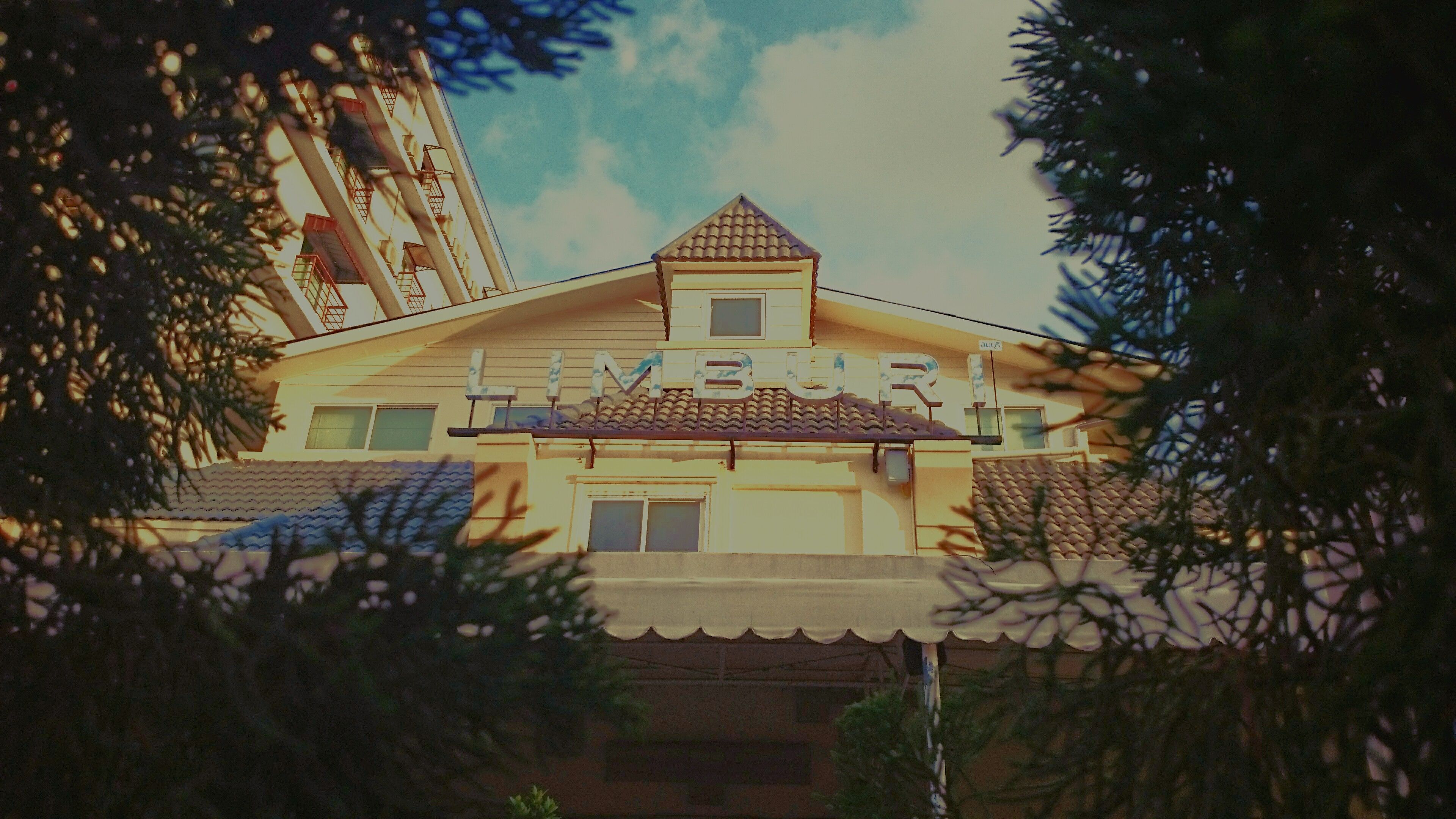 A building with a tiled roof and a sign that reads "MBUR".