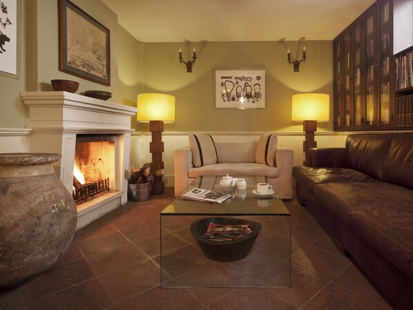 A cozy living room with a fireplace, a sofa, a leather couch, and a coffee table. - Hotel Ibrahim Pasha (Istanbul)