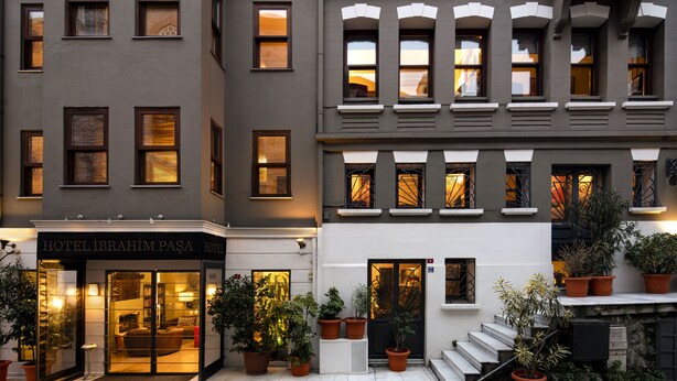 Un edificio de varios pisos con una entrada en la planta baja que dice 'HOTEL IBRAHIM PASA'.