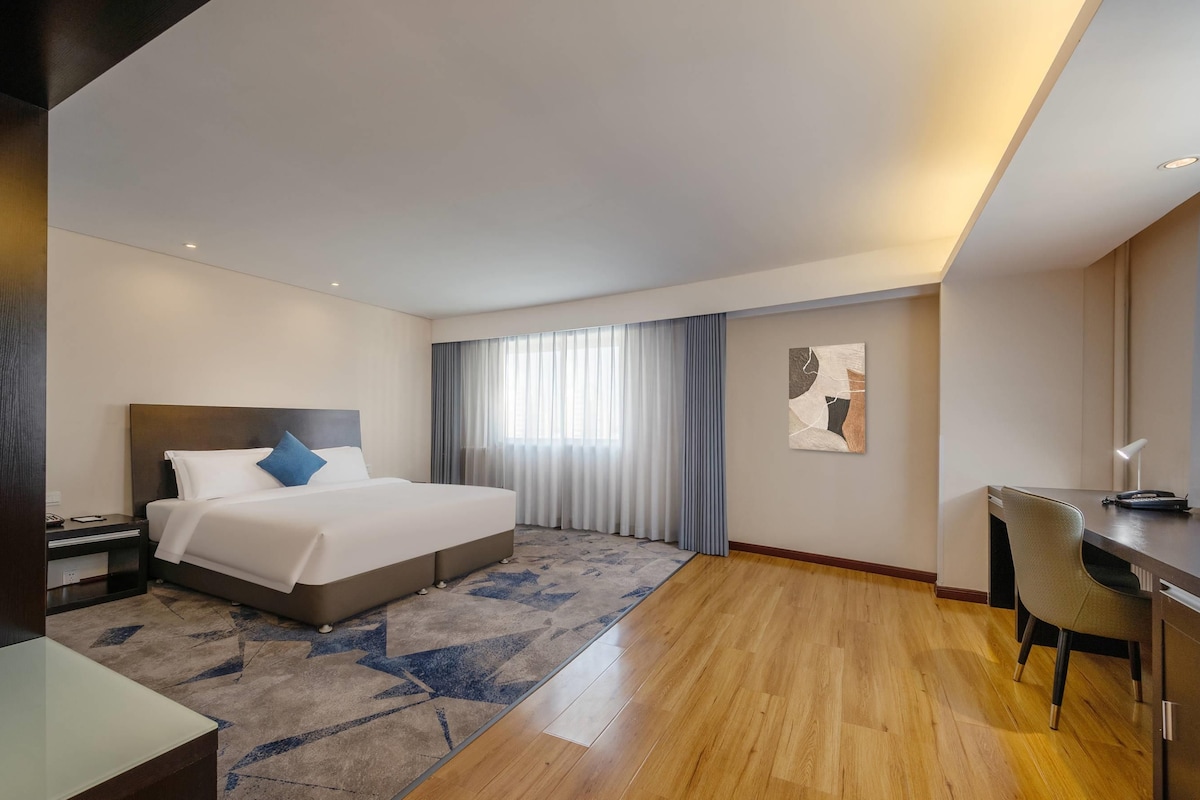 Una habitación de hotel con una cama, un escritorio y una silla.