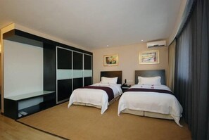A hotel room with two beds, a walk-in closet, and artwork on the walls. - Comfort Suites (Beijing)