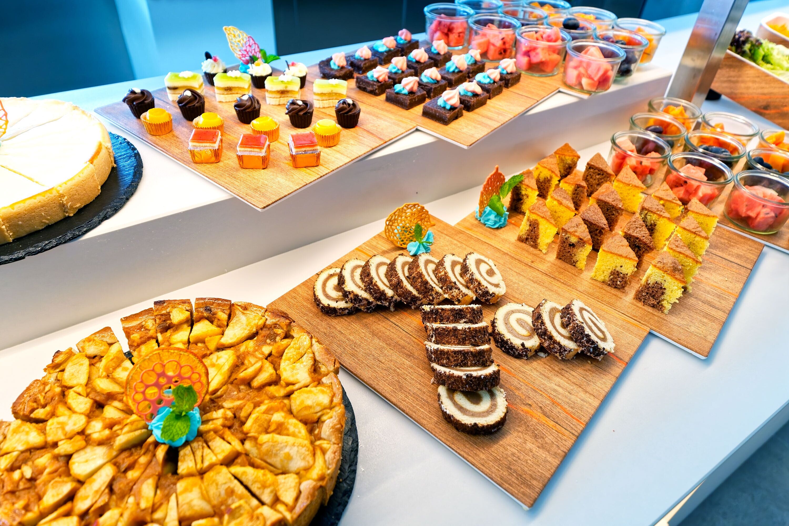 Un bufé con diversos postres y un pastel grande.