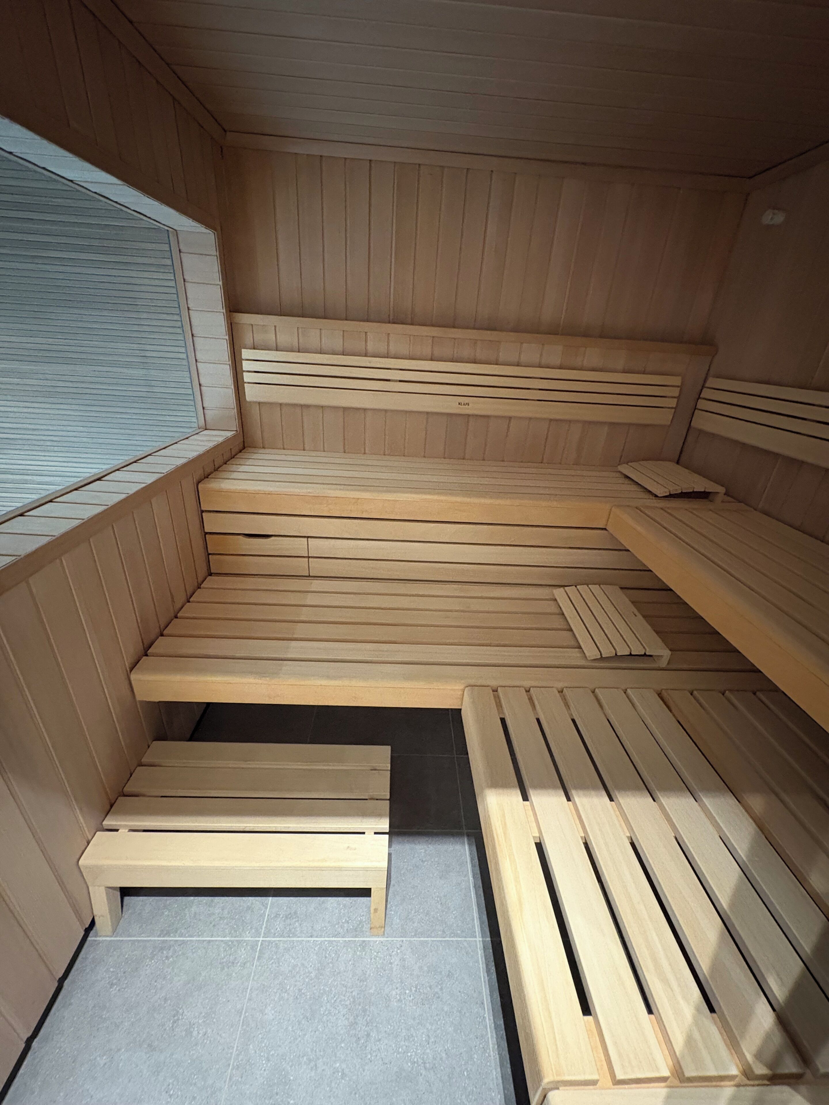A sauna with wooden benches and a tiled floor.