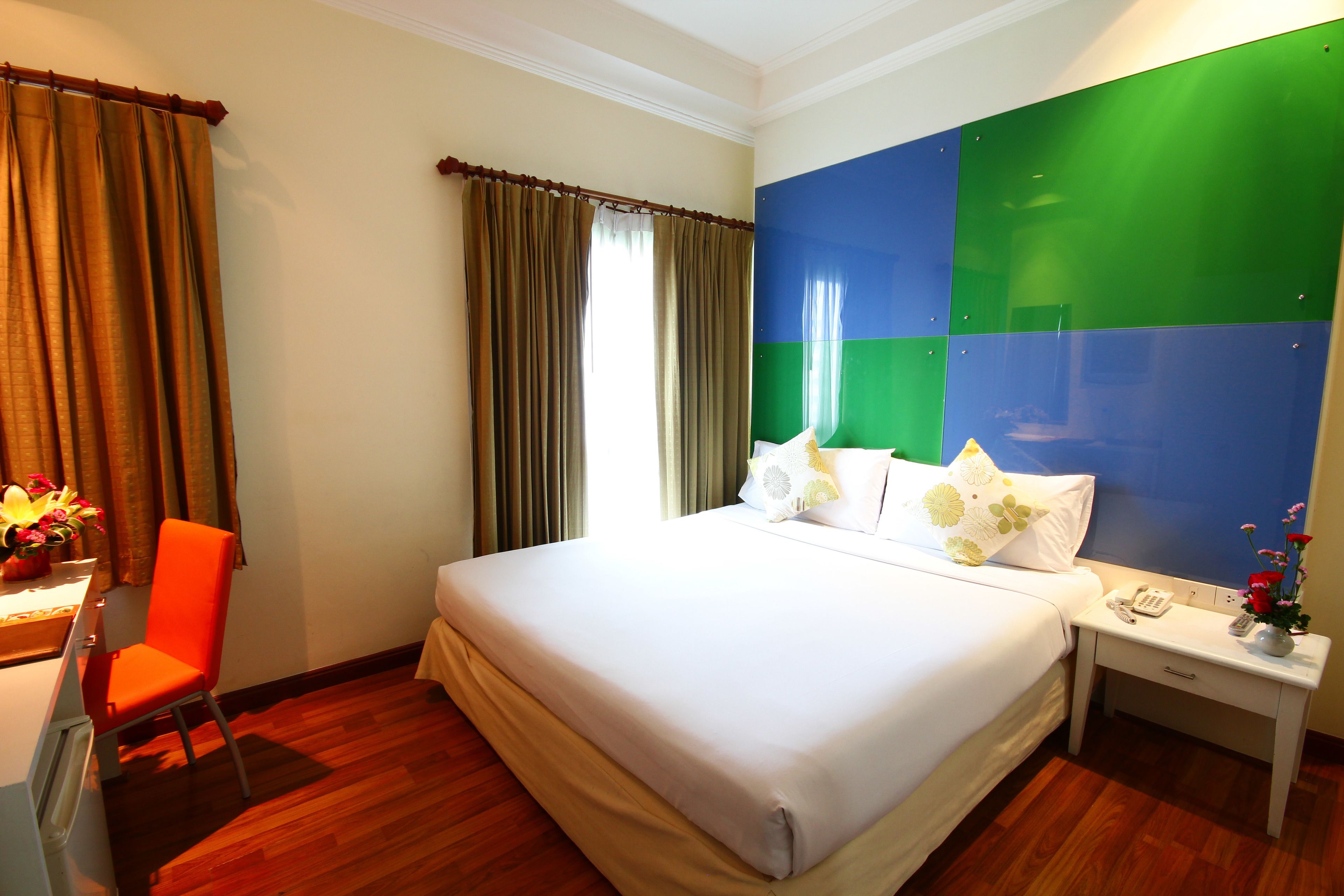 A hotel room with a bed, a desk, and a chair.