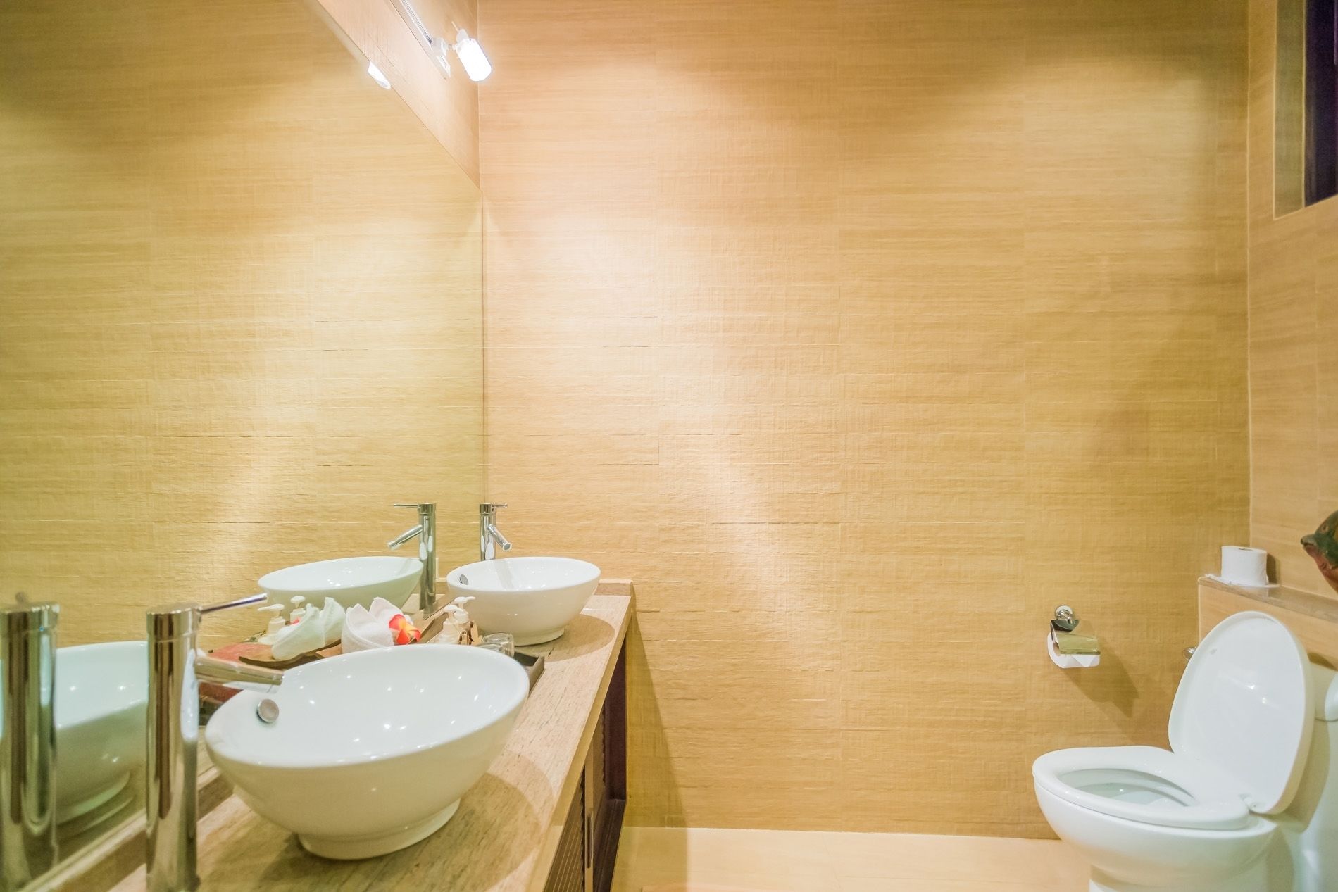 Un baño con dos lavamanos, un inodoro y un espejo.