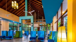 A spacious lobby with high ceilings, multiple seating areas, and large windows providing natural light.