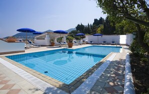 Una piscina techada, una piscina al aire libre de temporada, sombrillas