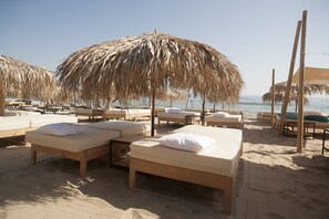 A beachside hotel with thatched umbrellas, wooden beds, and a view of the sea. - Villa Orange (Sozopol)