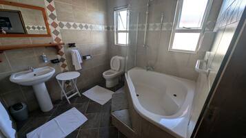 A bathroom with a bathtub, toilet, sink, and shower.