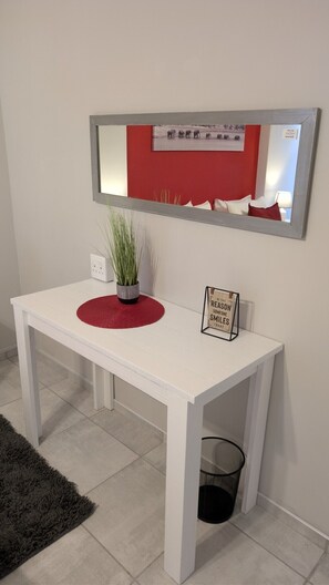 A white table with a red placemat, a potted plant, and a motivational sign.