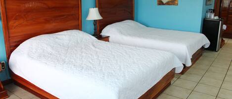 Uma cama de casal com cabeceira de madeira e uma mesa de cabeceira com abajur.