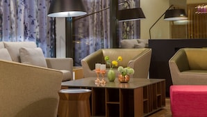 Un área de estar moderna con sofás, una mesa de centro e iluminación colgante.