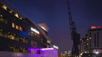 Un bâtiment moderne arborant les enseignes « Sunborn » et « Yacht Hotel », avec une grande grue visible à proximité.