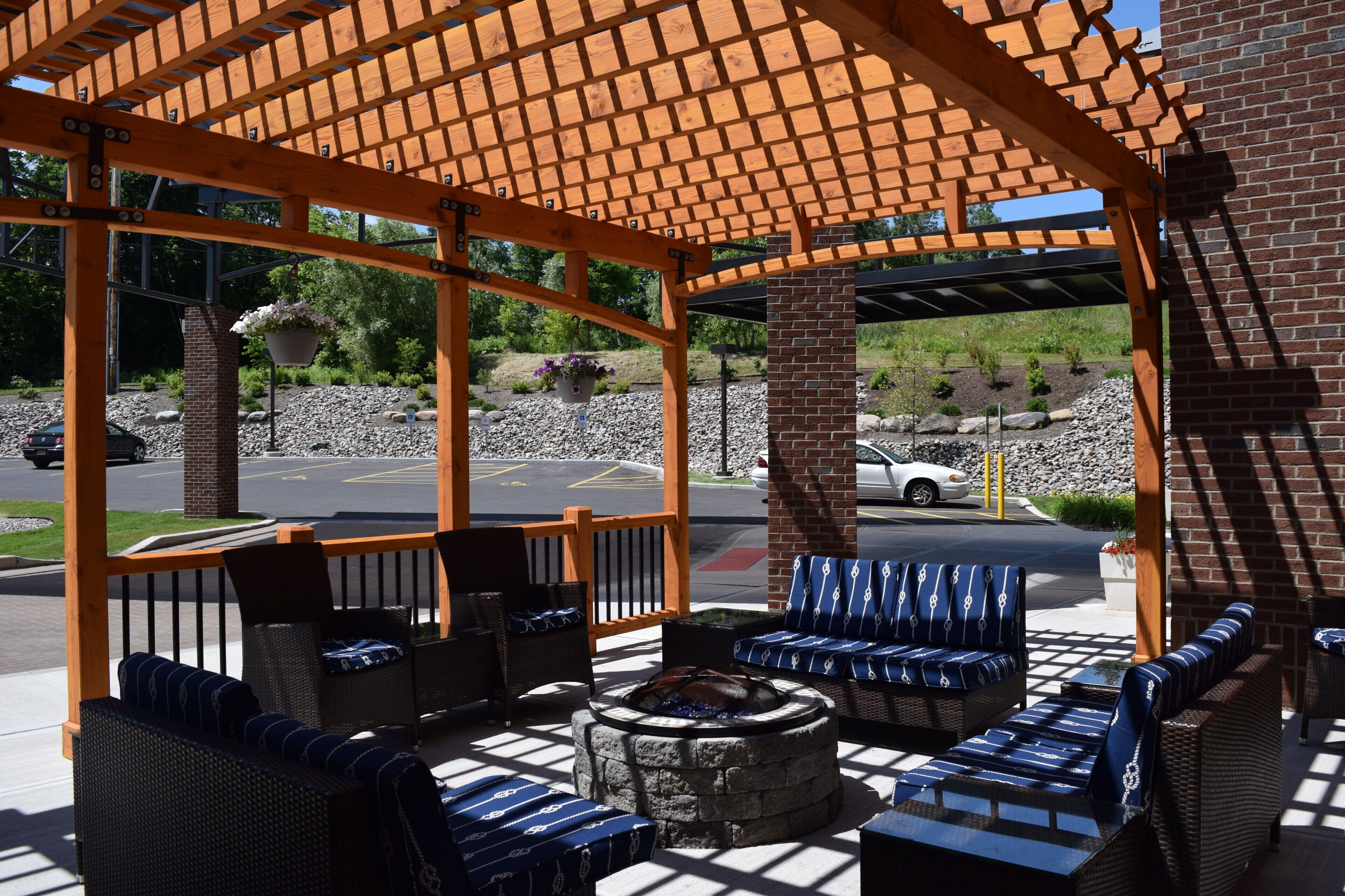 An outdoor seating area with wicker furniture and a stone fire pit.
